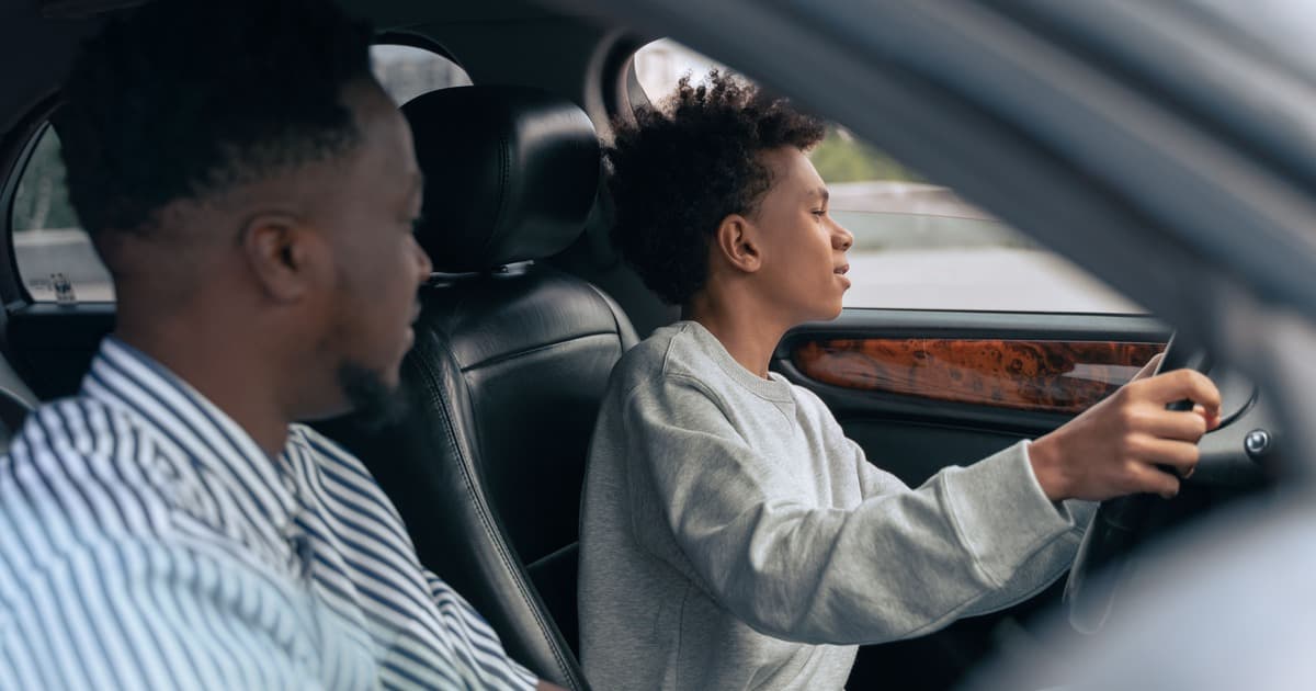 A teen driver at the wheel with an adult in the passenger seat during a supervised practice drive